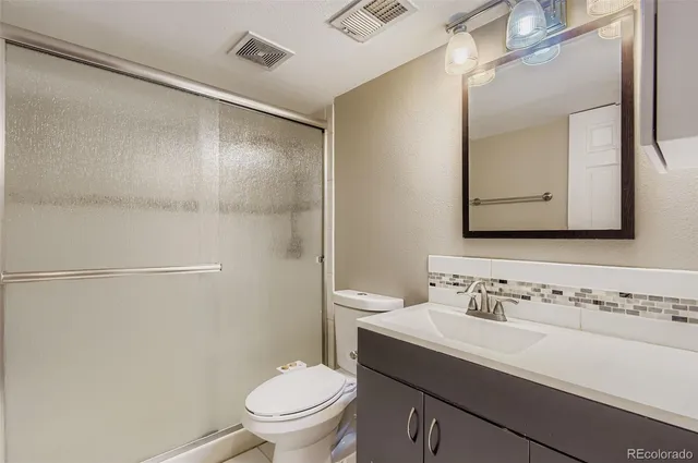 a bathroom with a sink toilet and mirror