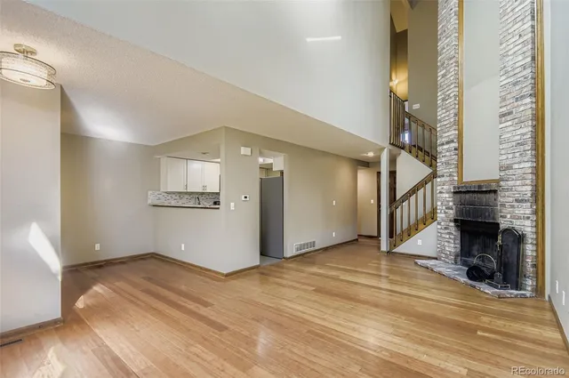 a view of empty room with wooden floor and fireplace