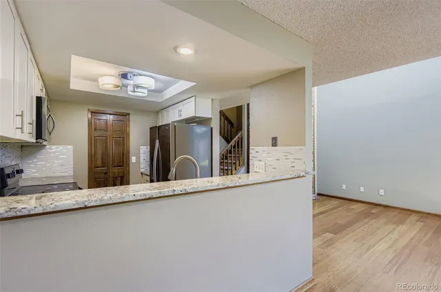 a view of a large kitchen with a sink and refrigerator