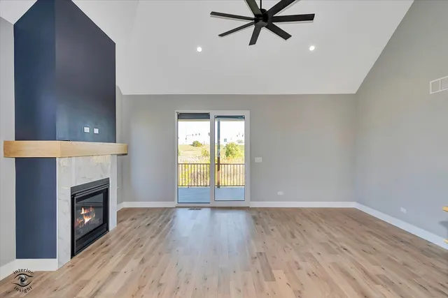 an empty room with a fireplace and wooden floor
