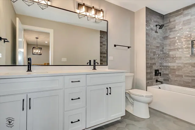 a bathroom with a double vanity sink toilet and shower