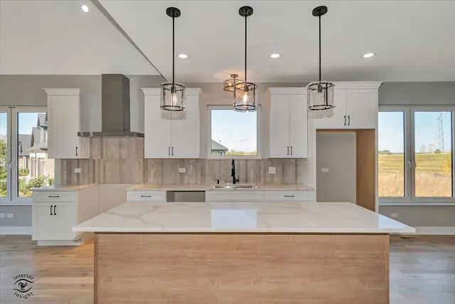 a kitchen with kitchen island granite countertop a sink a counter space appliances and cabinets