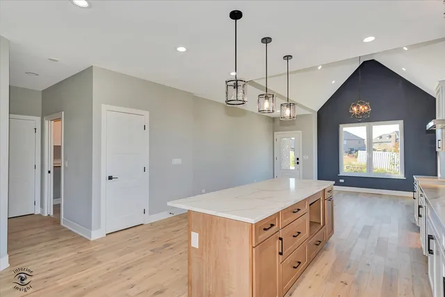 a kitchen with a sink a chandelier and wooden floor