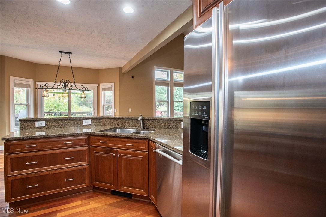 630 Rundle Street Lagrange, OH 44050 - Photo 14 of 49 Kitchen featuring appliances with stainless steel finishes, dark stone counters, light wood-style floors, pendant lighting, and a textured ceiling