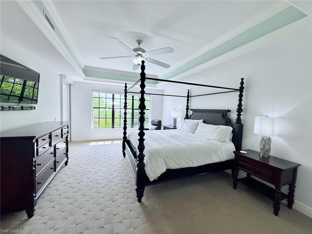705 10th Street South, Unit 301 Naples, FL 34102 - Photo 15 of 35 a bedroom with a bed a chandelier and next to a window