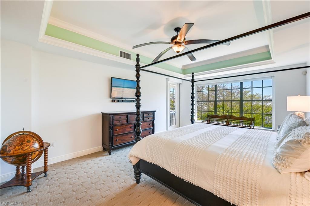 705 10th Street South, Unit 301 Naples, FL 34102 - Photo 17 of 35 a bedroom with a bed a chandelier and dresser