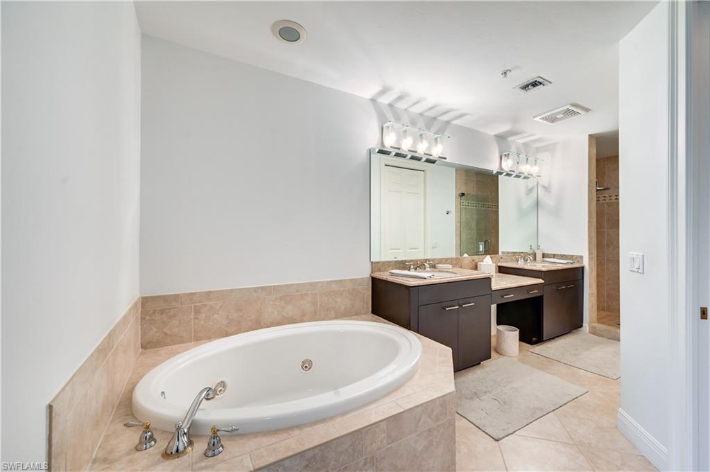 705 10th Street South, Unit 301 Naples, FL 34102 - Photo 18 of 35 a bathroom with a tub a sink and a mirror