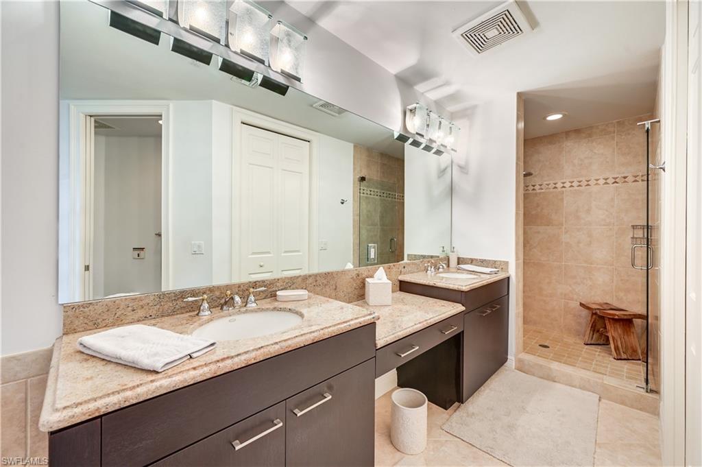 705 10th Street South, Unit 301 Naples, FL 34102 - Photo 19 of 35 a bathroom with a granite countertop sink a toilet a mirror and shower