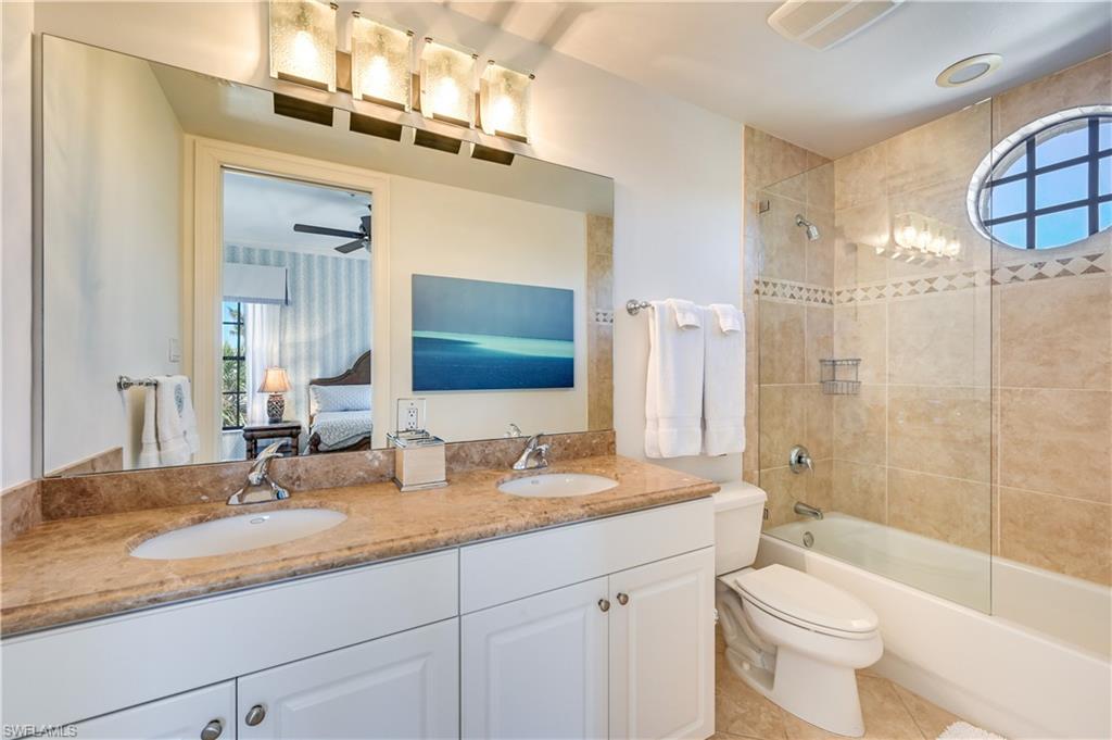 705 10th Street South, Unit 301 Naples, FL 34102 - Photo 26 of 35 a bathroom with a granite countertop sink toilet and shower