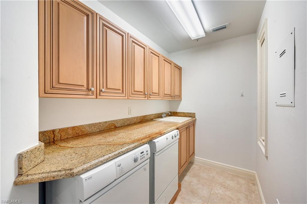 705 10th Street South, Unit 301 Naples, FL 34102 - Photo 30 of 35 a utility room with granite countertop cabinets washer and dryer