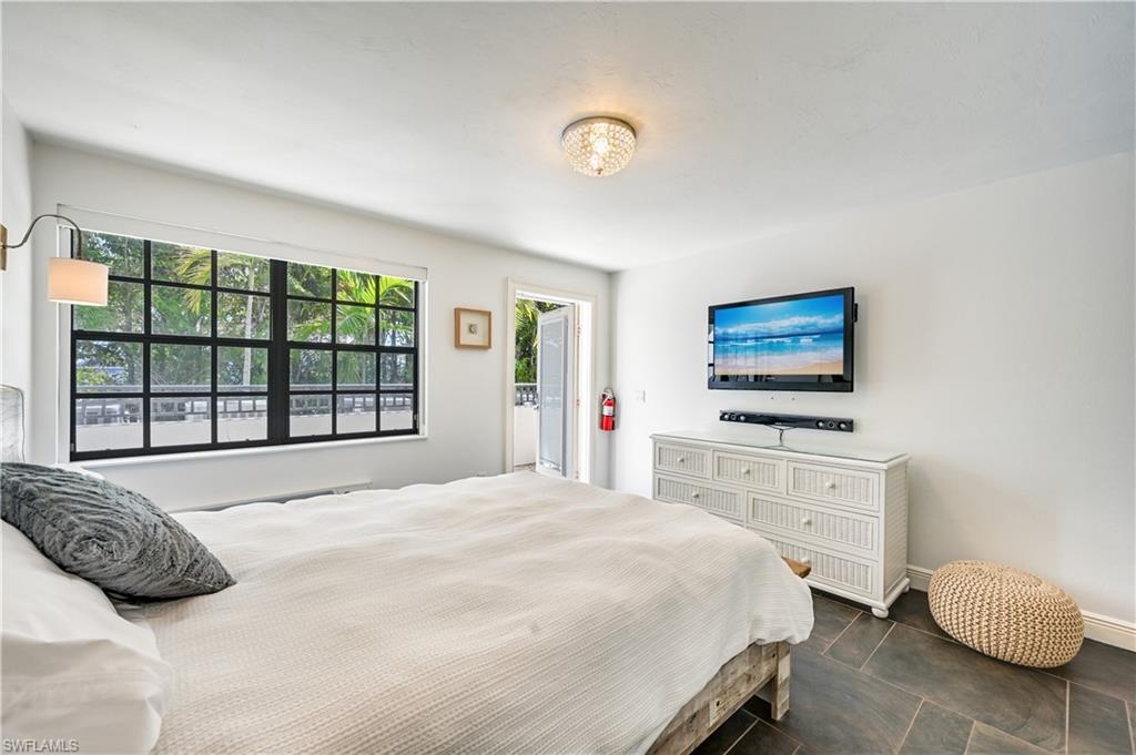 705 10th Street South, Unit 301 Naples, FL 34102 - Photo 33 of 35 a bedroom with a bed and a flat screen tv