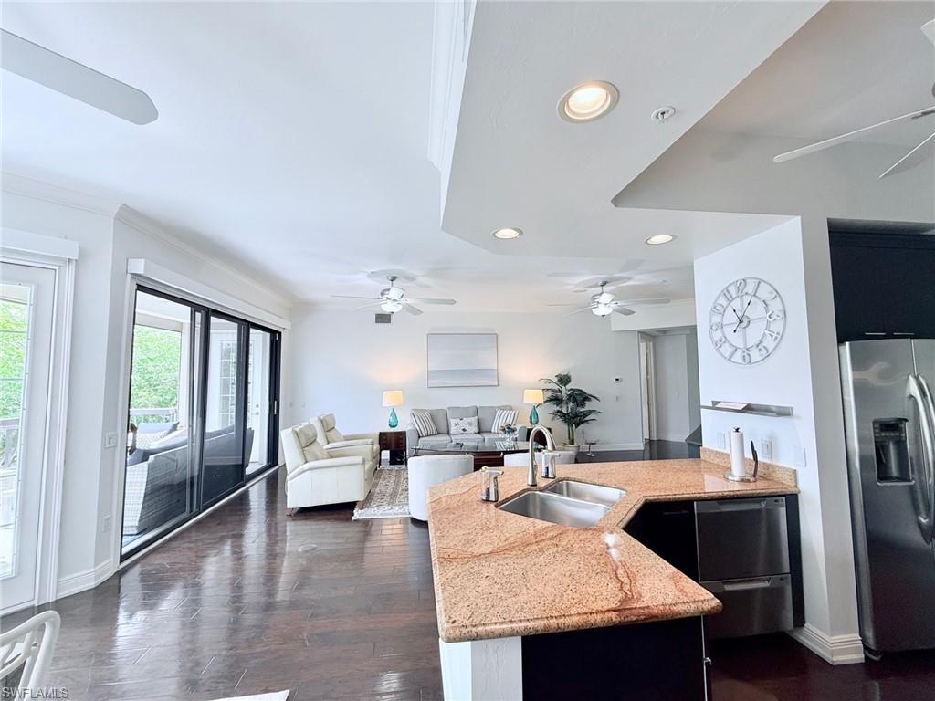 705 10th Street South, Unit 301 Naples, FL 34102 - Photo 35 of 35 a living room with stainless steel appliances granite countertop furniture a fireplace a rug and a large window