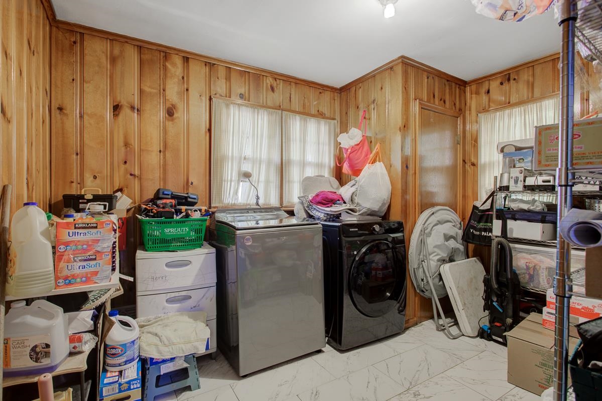 1019 Tatum Road Memphis, TN 38122 - Photo 8 of 21 Laundry area featuring washer and clothes dryer, wood walls, and light marble finish flooring