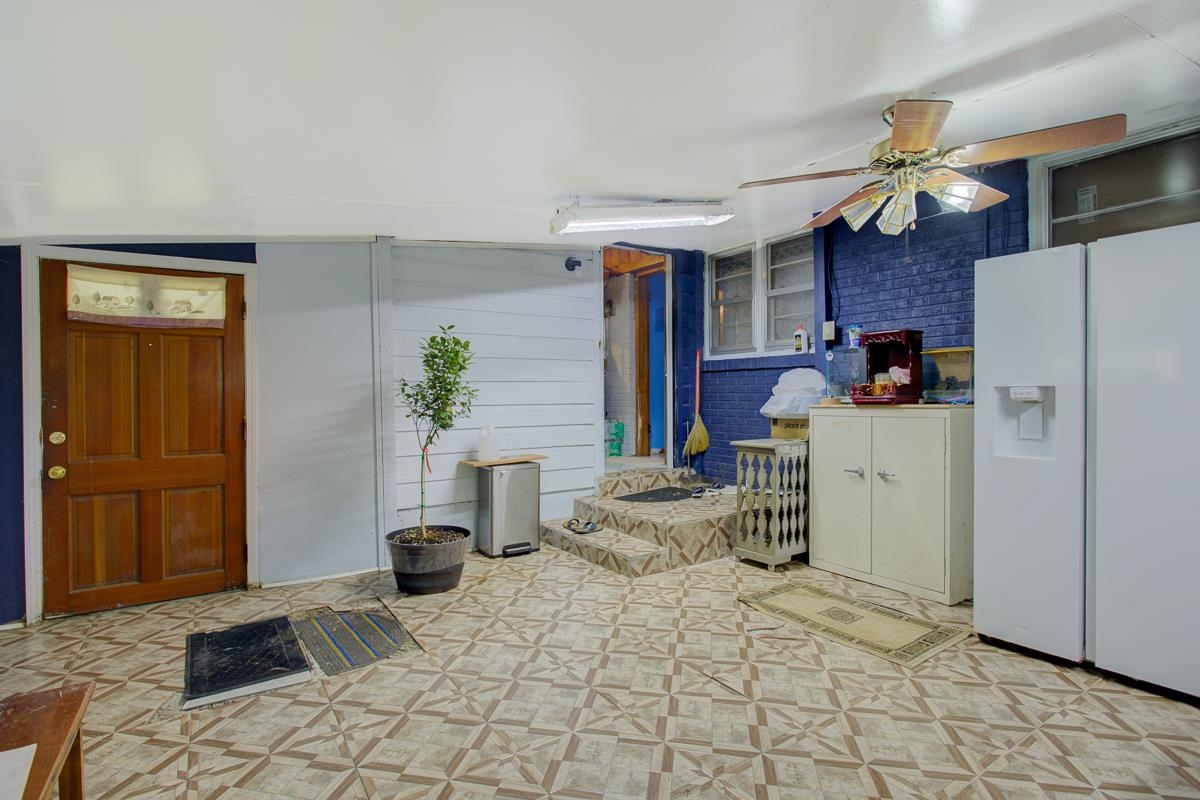 1019 Tatum Road Memphis, TN 38122 - Photo 10 of 21 Kitchen featuring a ceiling fan, white fridge with ice dispenser, and brick wall