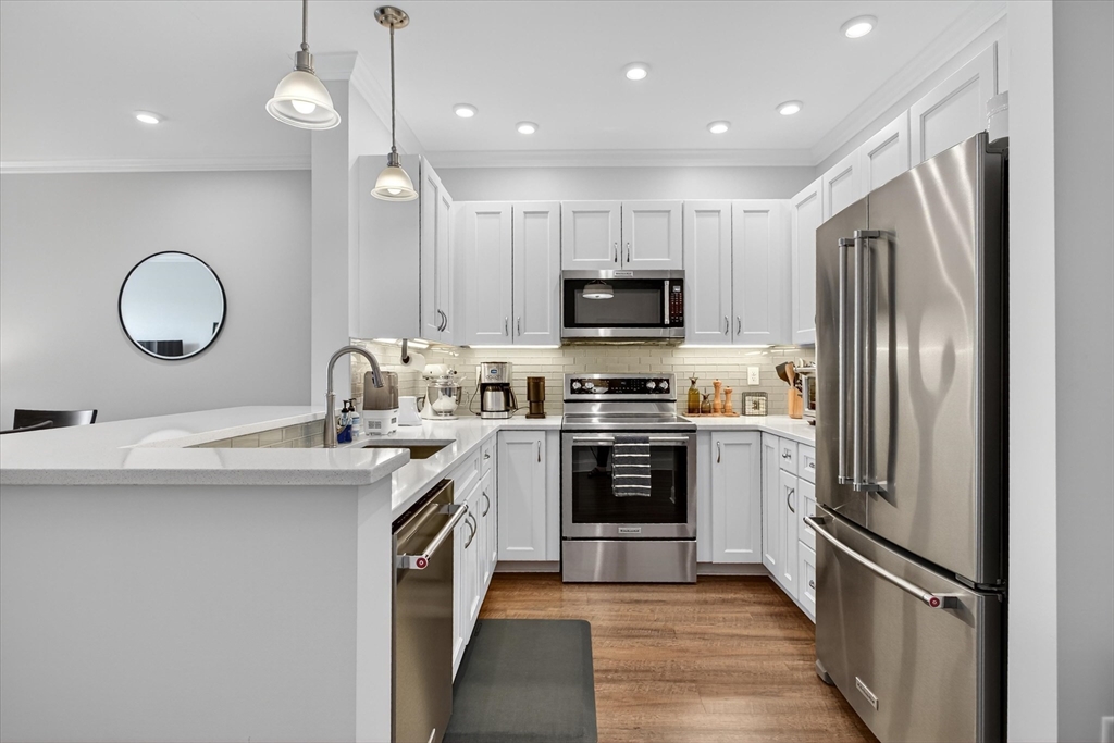 69 Foundry Street, Unit 314 Wakefield, MA 01880 - Photo 2 of 27 a kitchen with kitchen island granite countertop stainless steel appliances and a sink