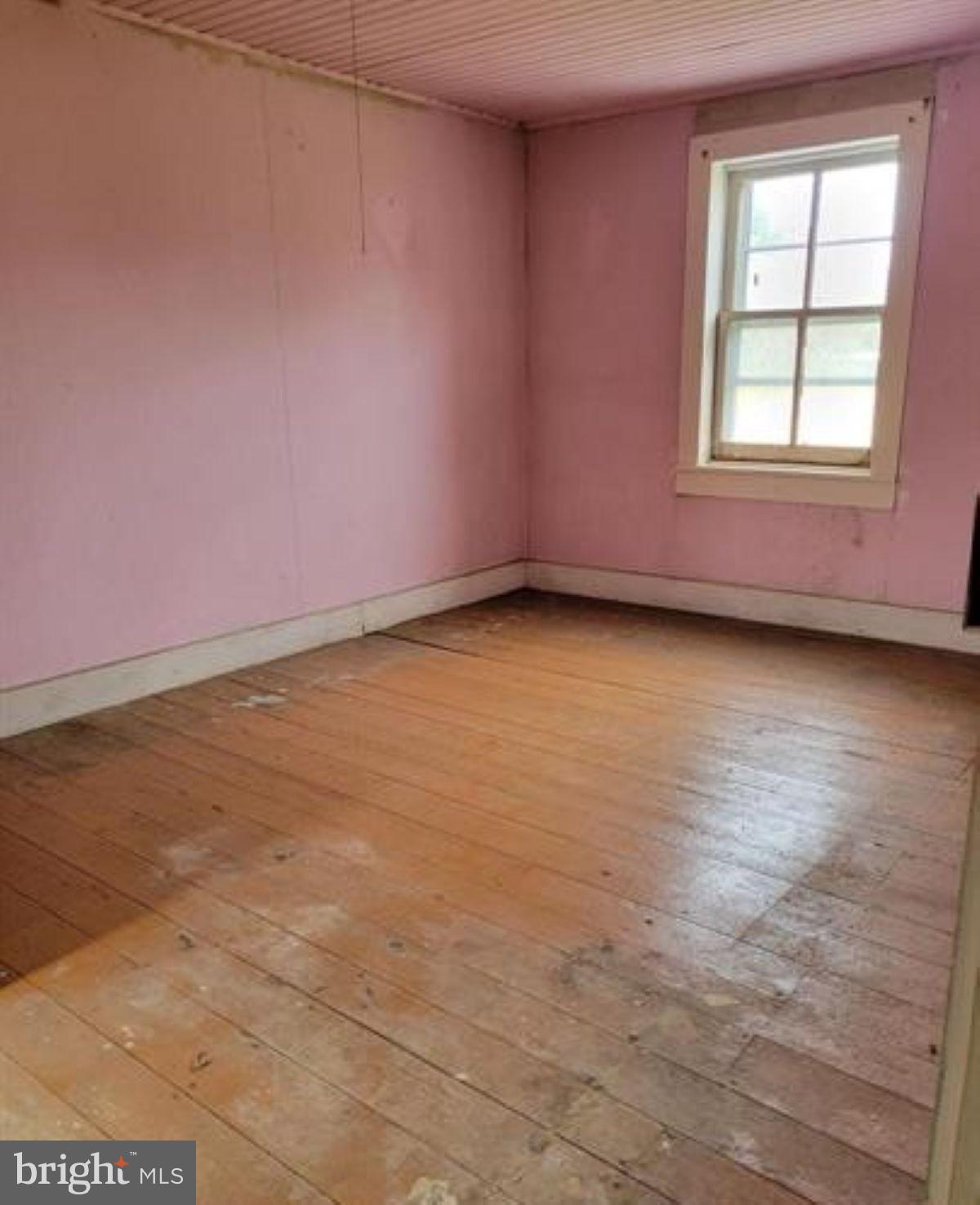 99 Little Cacapon Road Romney, WV 26757 - Photo 10 of 25 an empty room with wooden floor and windows