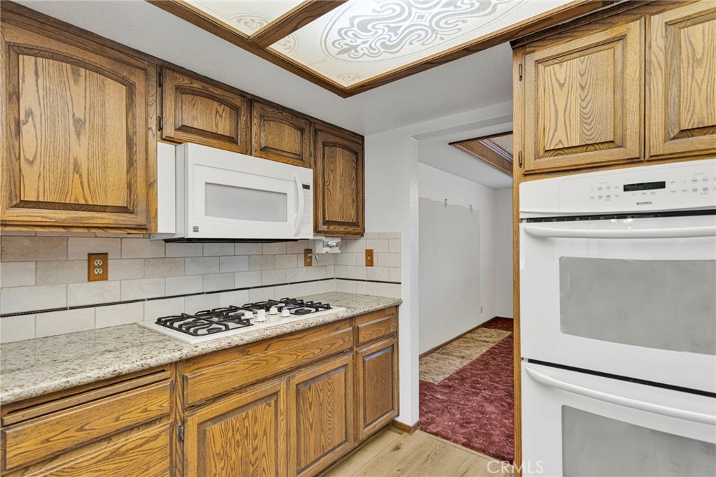 16224 Olalee Road Apple Valley, CA 92307 - Photo 12 of 48 a kitchen with stainless steel appliances granite countertop a stove and a microwave