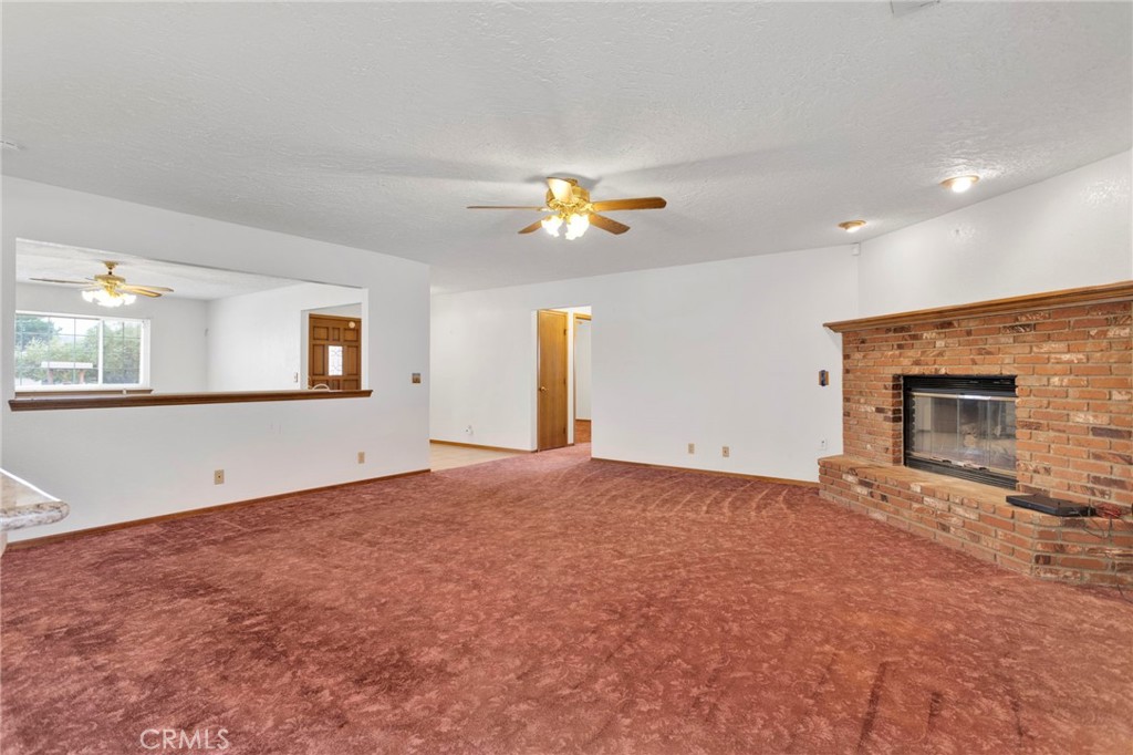 16224 Olalee Road Apple Valley, CA 92307 - Photo 15 of 48 an empty room with a fireplace and fan