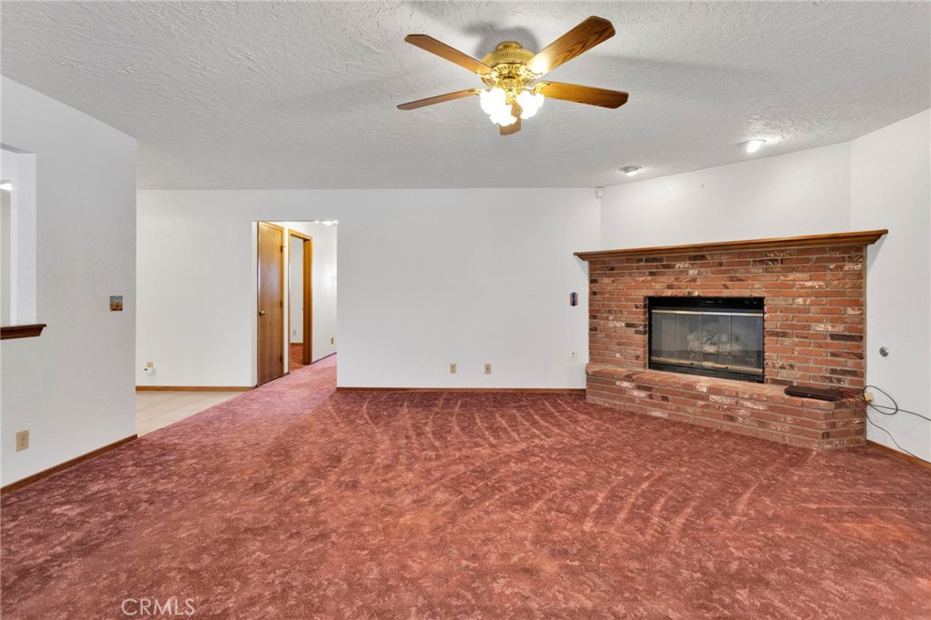 16224 Olalee Road Apple Valley, CA 92307 - Photo 16 of 48 an empty room with fireplace and fan
