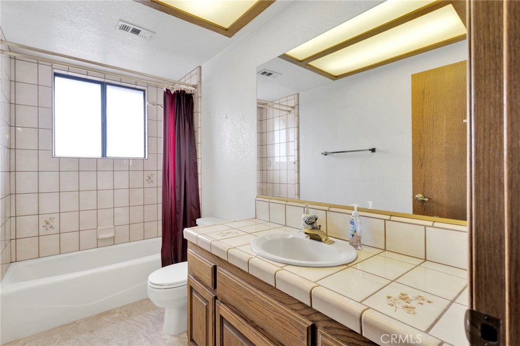16224 Olalee Road Apple Valley, CA 92307 - Photo 22 of 48 a bathroom with a granite countertop sink toilet and shower