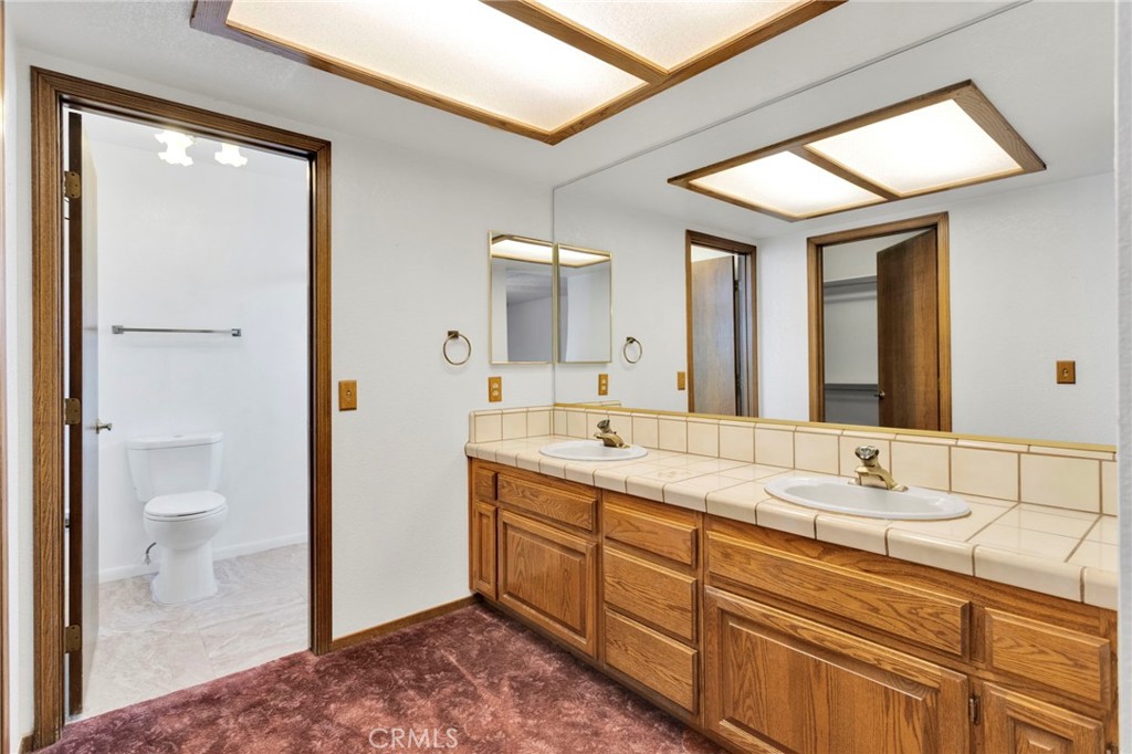 16224 Olalee Road Apple Valley, CA 92307 - Photo 25 of 48 a spacious bathroom with a double vanity sink and a mirror