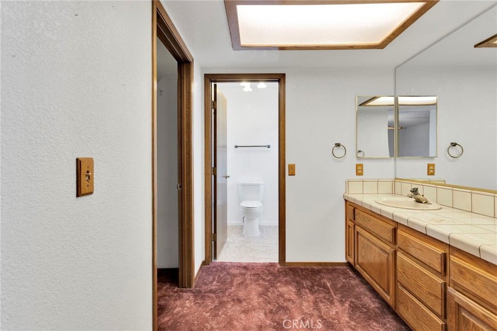 16224 Olalee Road Apple Valley, CA 92307 - Photo 26 of 48 a spacious bathroom with a granite countertop sink a mirror and a shower