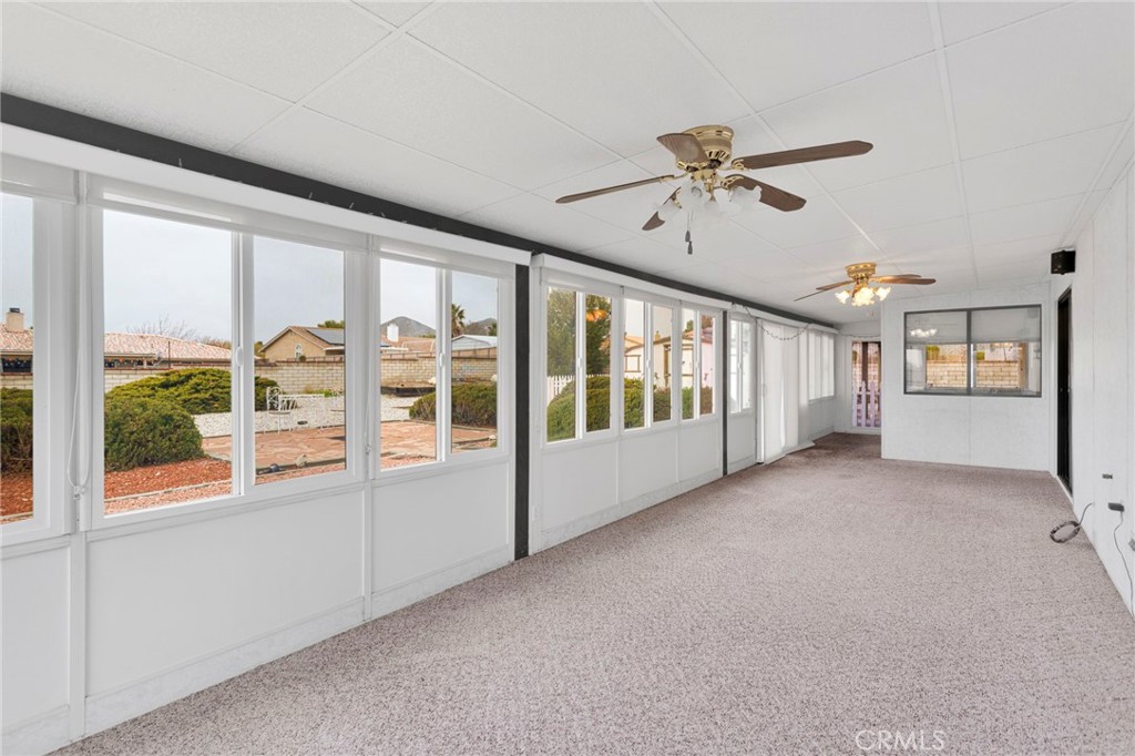 16224 Olalee Road Apple Valley, CA 92307 - Photo 32 of 48 a view of a livingroom with furniture a ceiling fan and windows