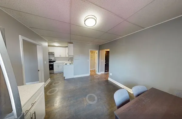 a view of a hallway with wooden floor and a refrigerator
