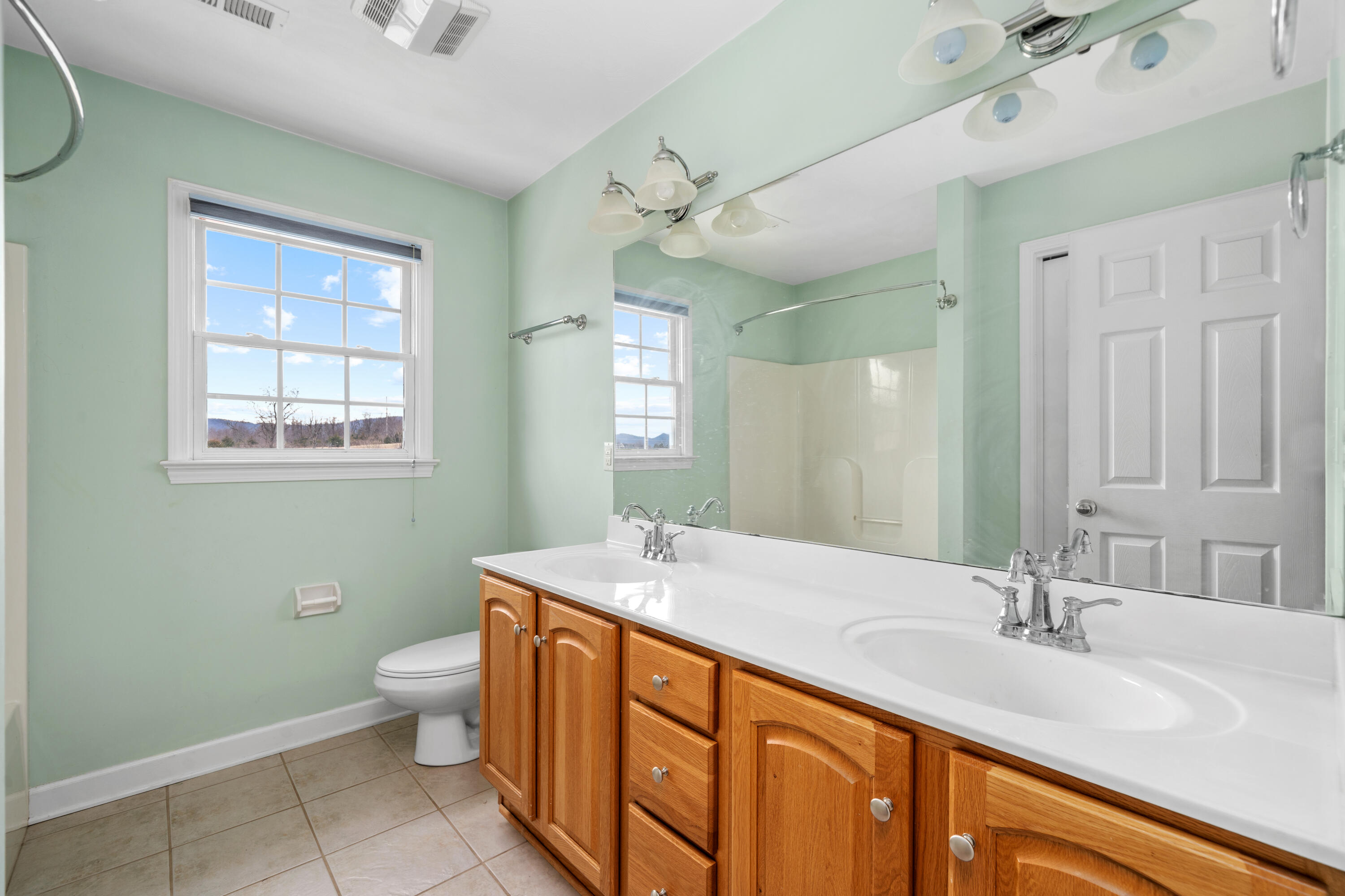 765 Country Club Road Troutville, VA 24175 - Photo 20 of 29 a bathroom with a granite countertop sink a large mirror a toilet and a bathtub