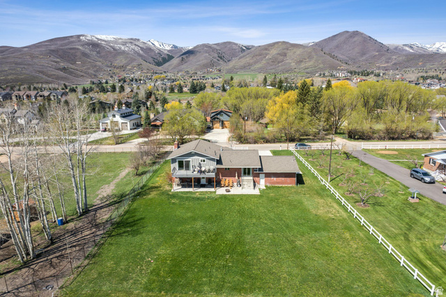 550 Pine Canyon Road Midway, UT 84049 - Photo 43 of 44 Expansive property with a verdant lawn, a two-story residence featuring a ground-level patio and an upper-level deck, and a distinct brick-clad extension