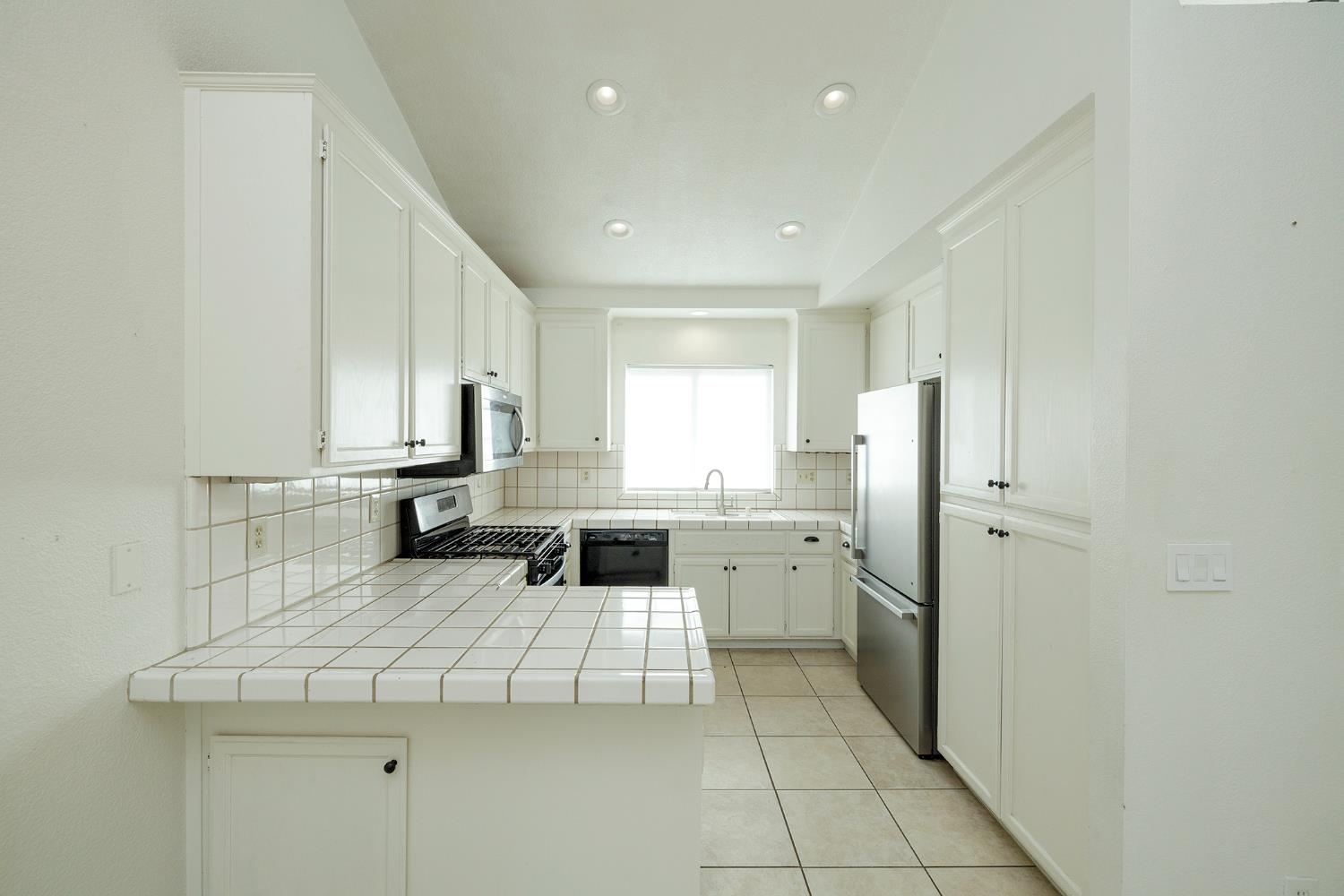 4093 Heartland Way Turlock, CA 95382 - Photo 13 of 43 a kitchen with a refrigerator a sink and cabinets
