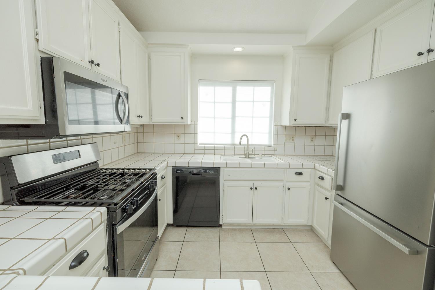 4093 Heartland Way Turlock, CA 95382 - Photo 14 of 43 a kitchen with cabinets appliances a sink and a window