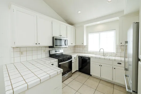 a kitchen with a sink appliances and cabinets