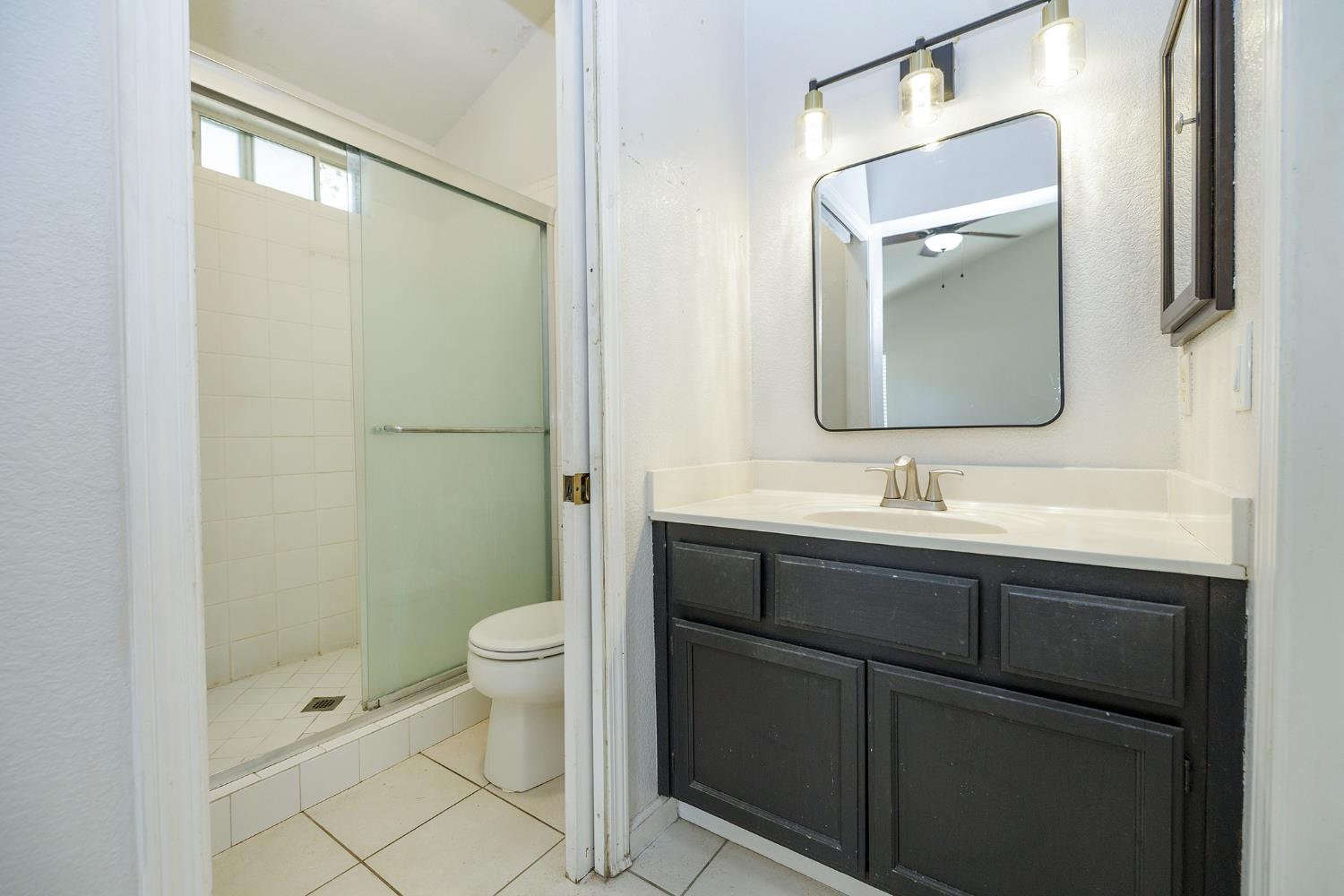 4093 Heartland Way Turlock, CA 95382 - Photo 22 of 43 a bathroom with a toilet a sink a mirror a shower and vanity