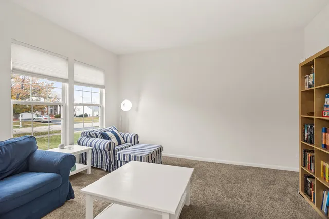 a living room with furniture and a book shelf