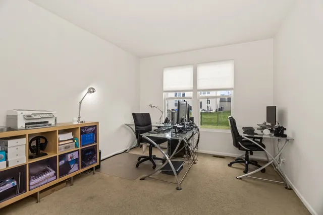 a view of a workspace with furniture and a window