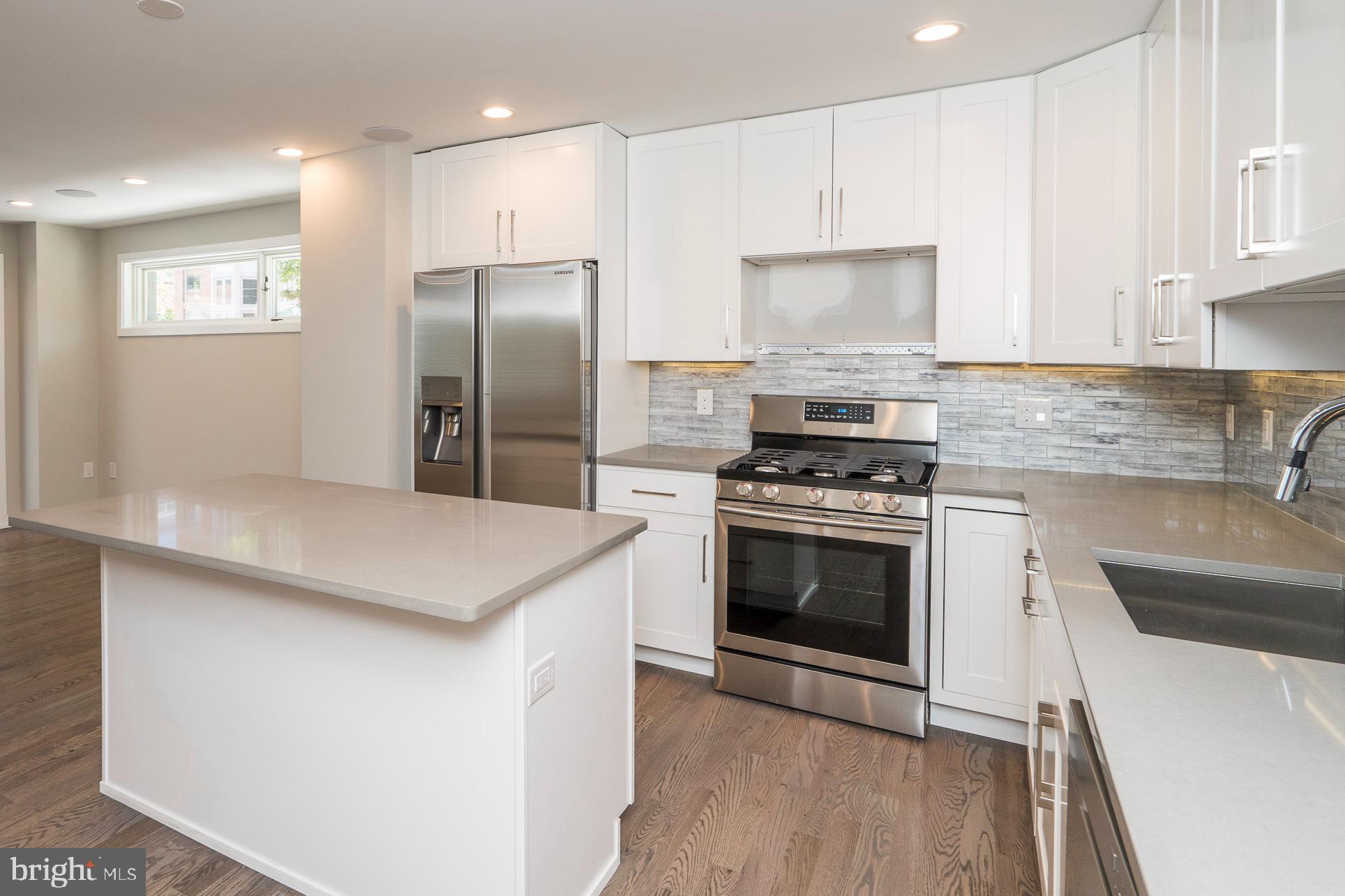 a kitchen with a stove a refrigerator and a sink