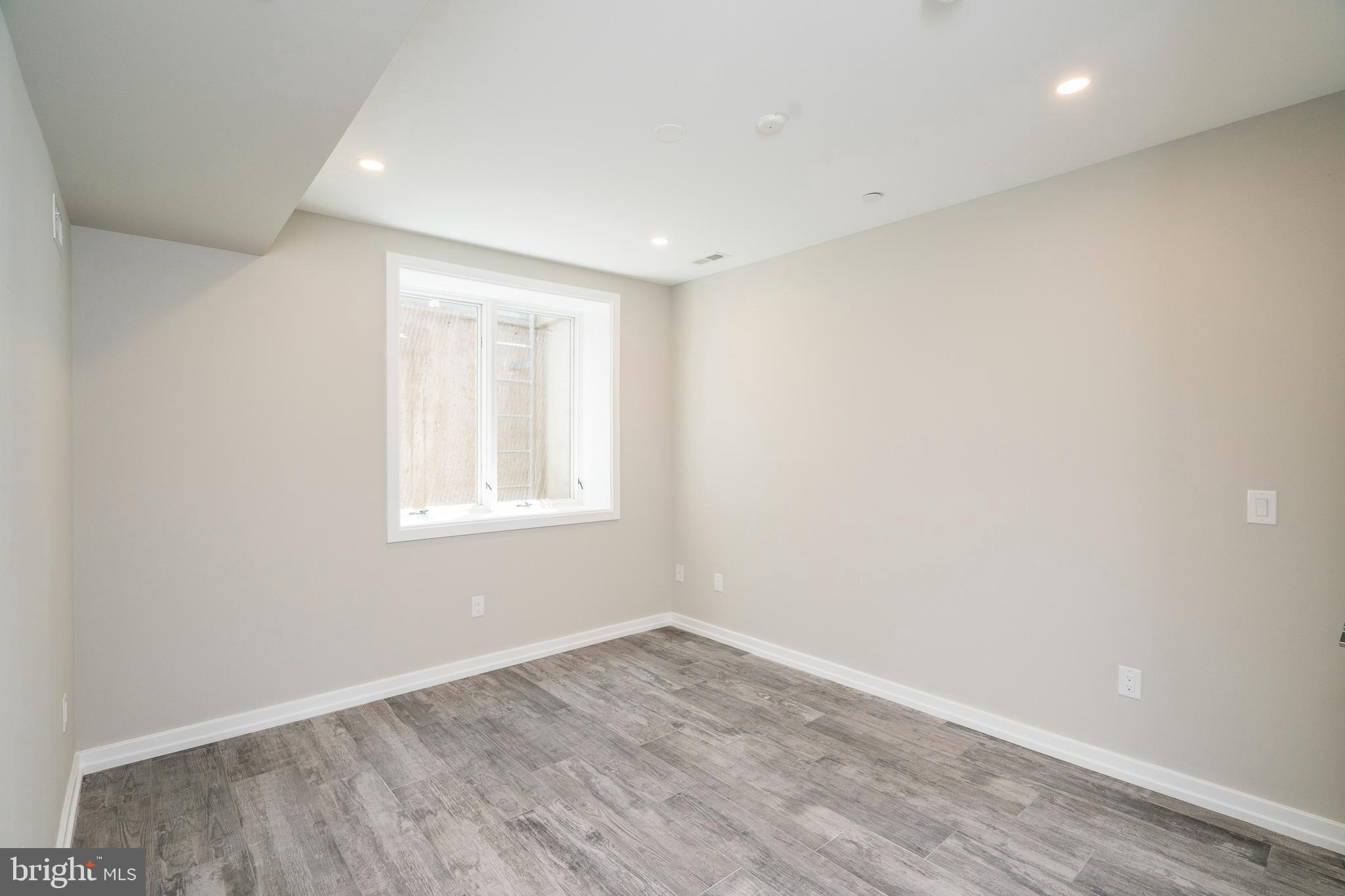 1701 Bainbridge Street, Unit 1 Philadelphia, PA 19146 - Photo 13 of 20 an empty room with wooden floor and windows