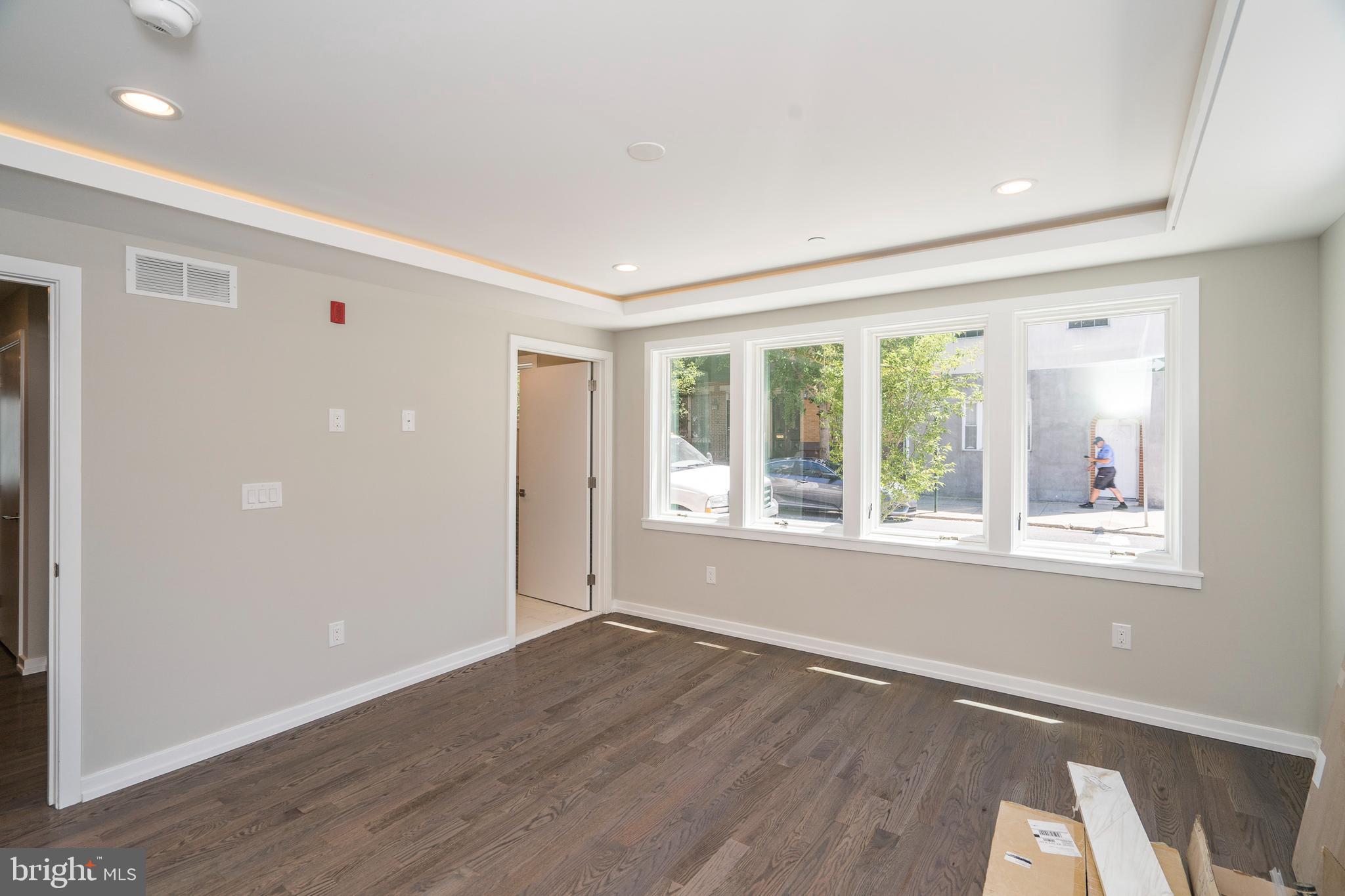 1701 Bainbridge Street, Unit 1 Philadelphia, PA 19146 - Photo 7 of 20 a view of an empty room with wooden floor and a window