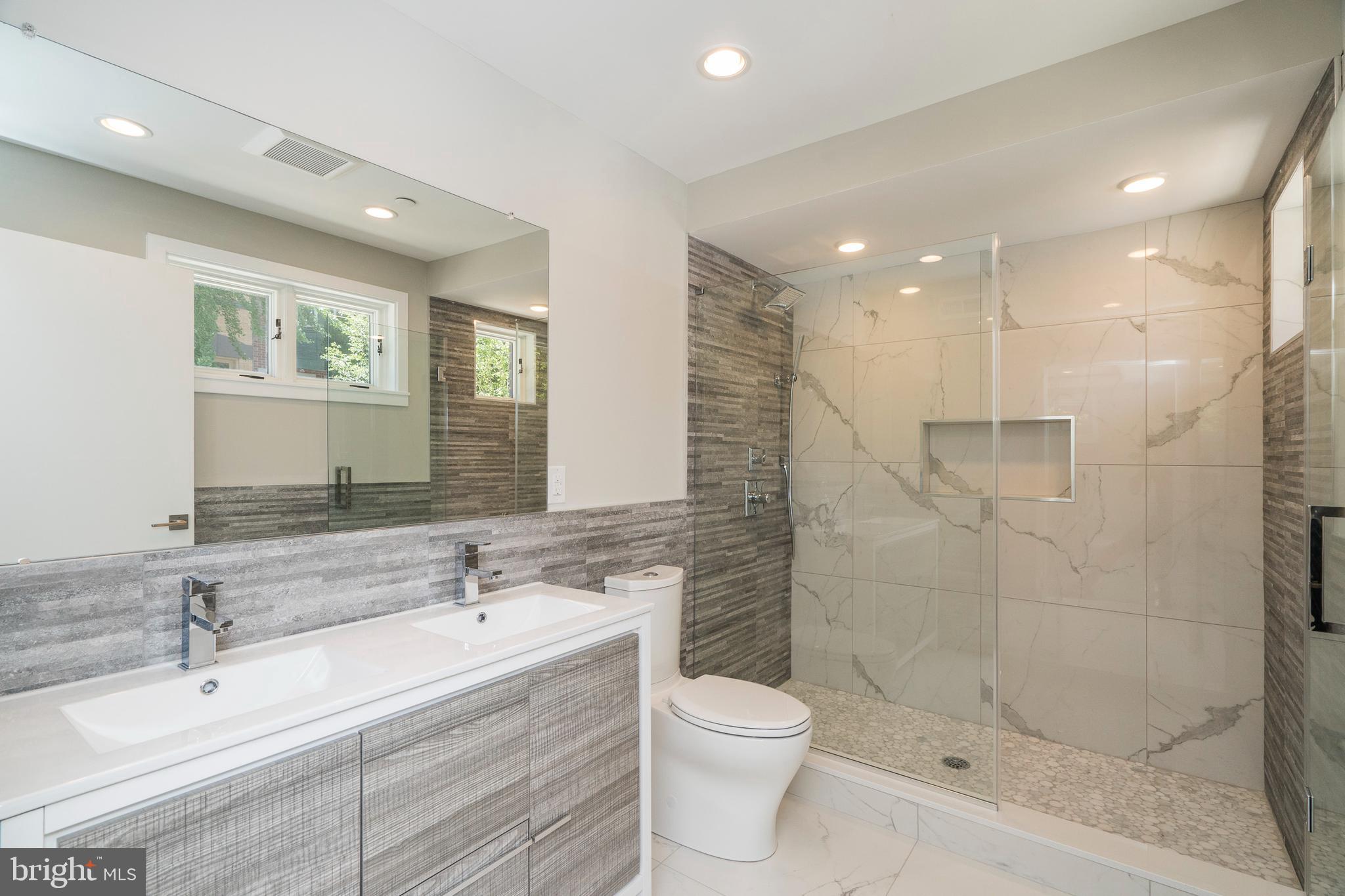 1701 Bainbridge Street, Unit 1 Philadelphia, PA 19146 - Photo 9 of 20 a bathroom with a double vanity sink toilet and shower