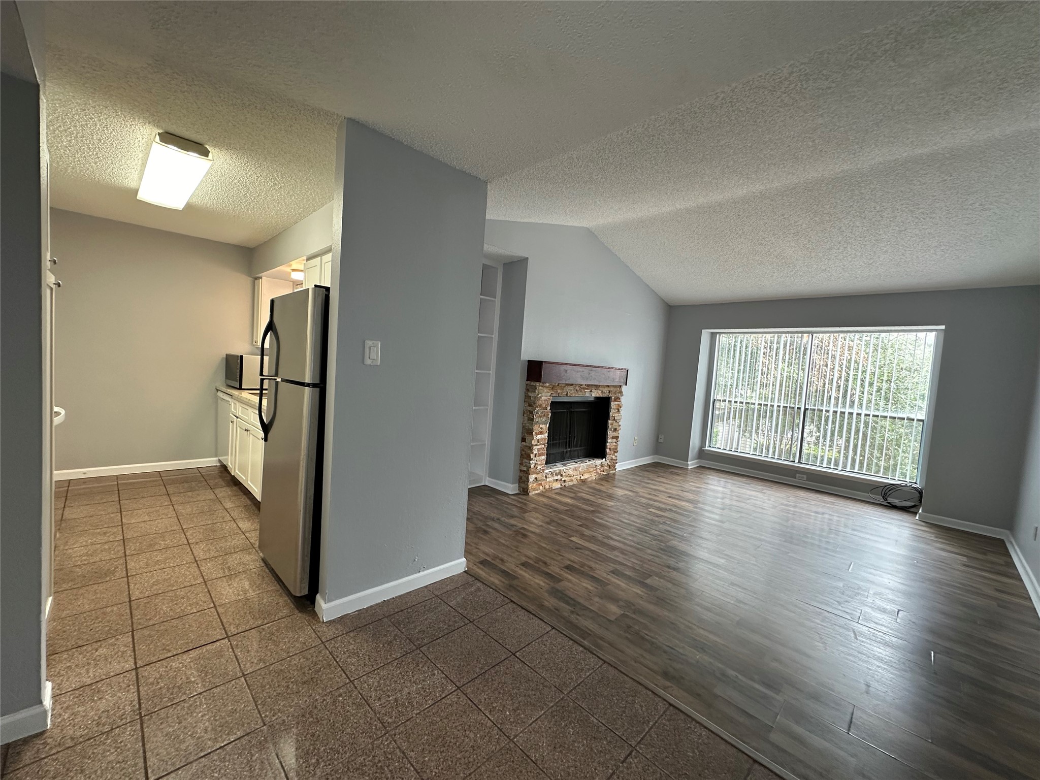 6701 Sands Point Drive, Unit 66 Houston, TX 77074 - Photo 11 of 19 an empty room with windows and a refrigerator