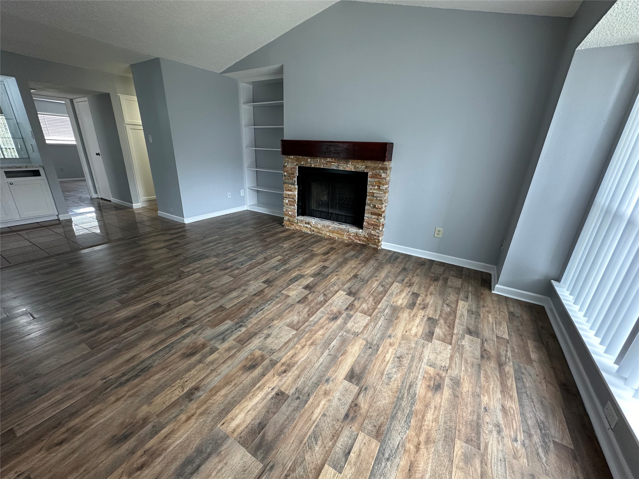 6701 Sands Point Drive, Unit 66 Houston, TX 77074 - Photo 3 of 19 a view of empty room with wooden floor and fireplace