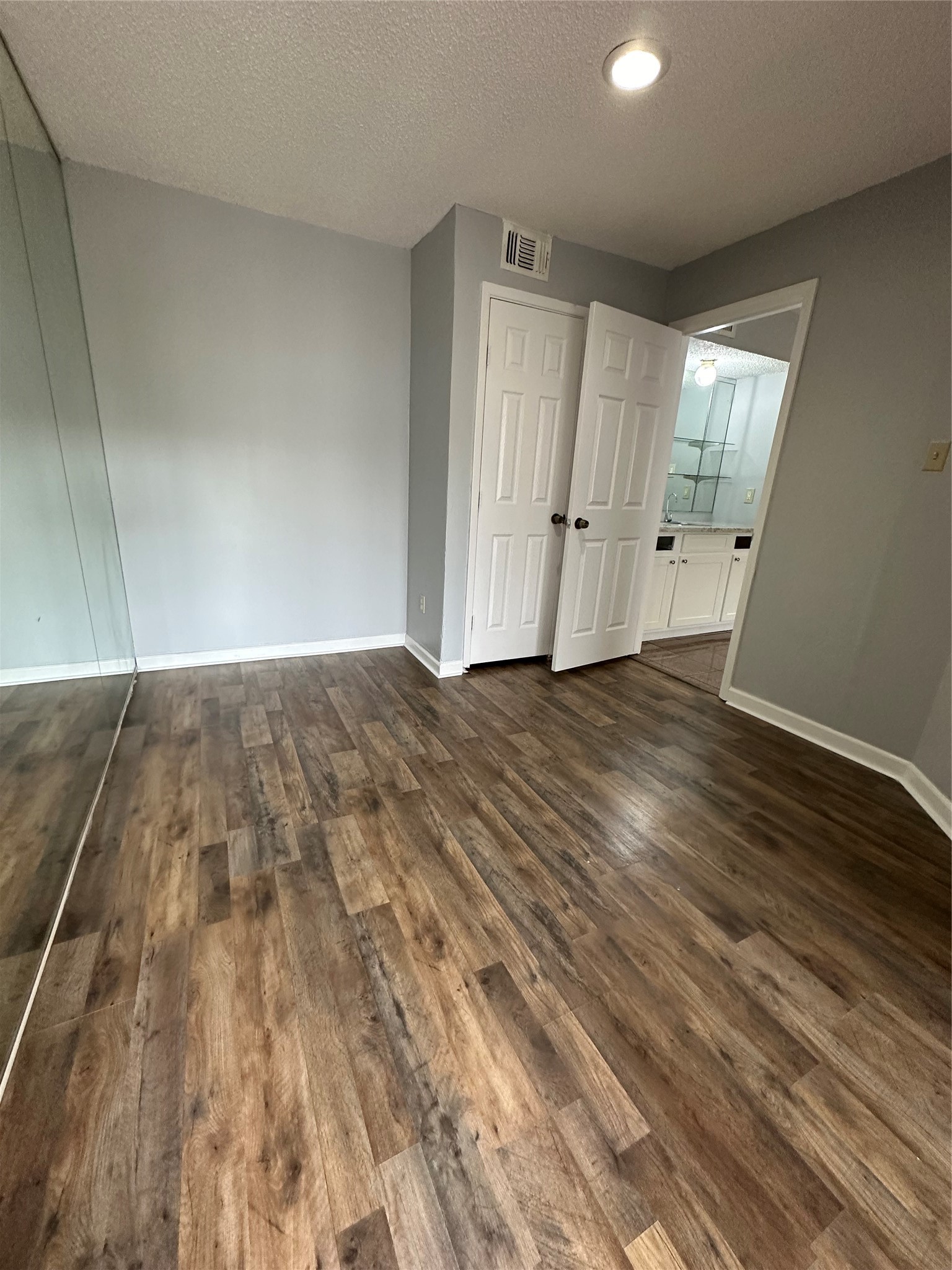 6701 Sands Point Drive, Unit 66 Houston, TX 77074 - Photo 5 of 19 an empty room with wooden floor and mirror