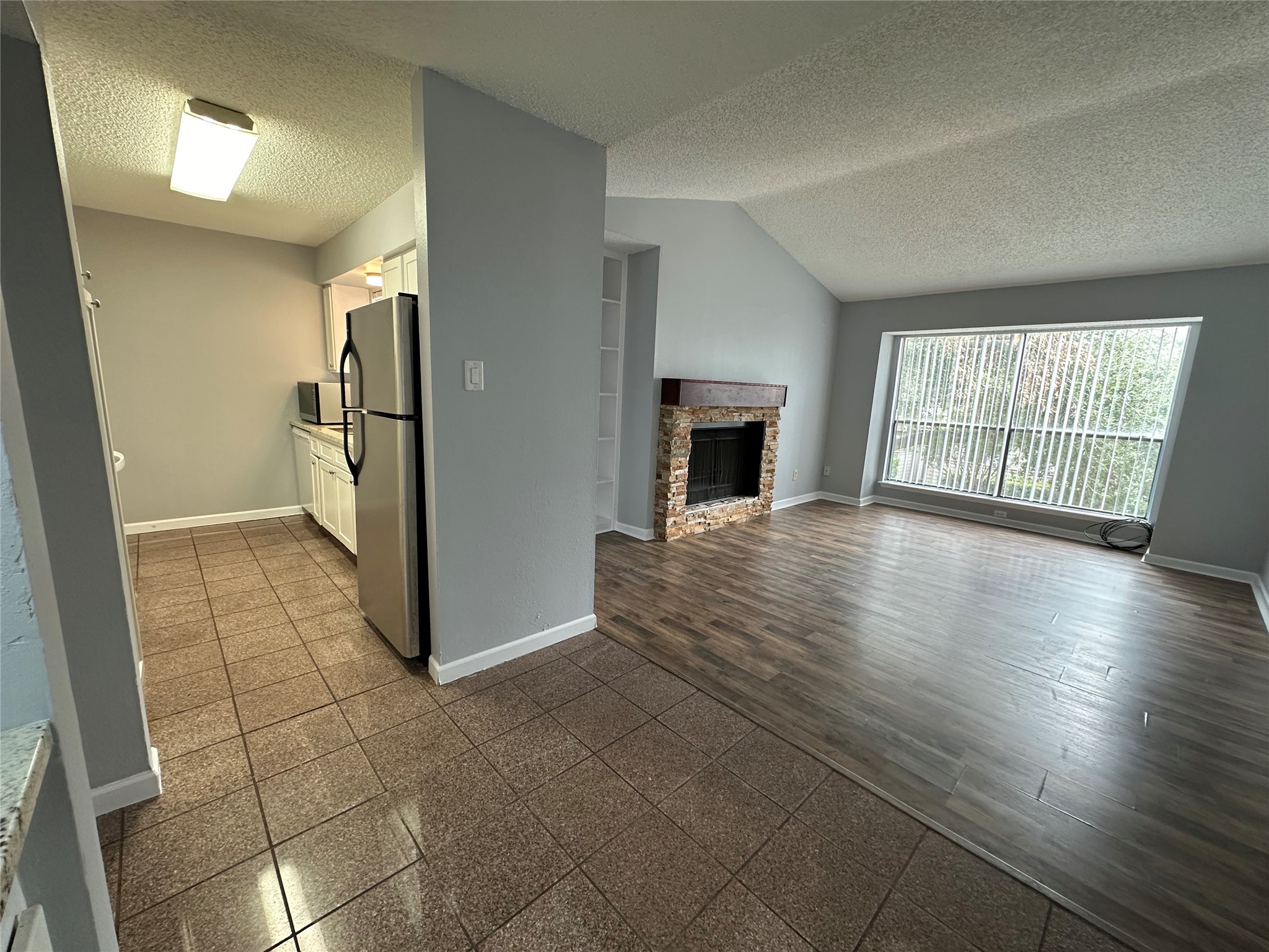 6701 Sands Point Drive, Unit 66 Houston, TX 77074 - Photo 6 of 19 wooden floor in an empty room with a fireplace