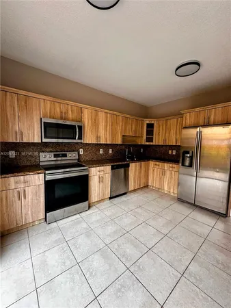 a kitchen with granite countertop a stove and a refrigerator