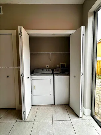 a utility room with cabinets and washer