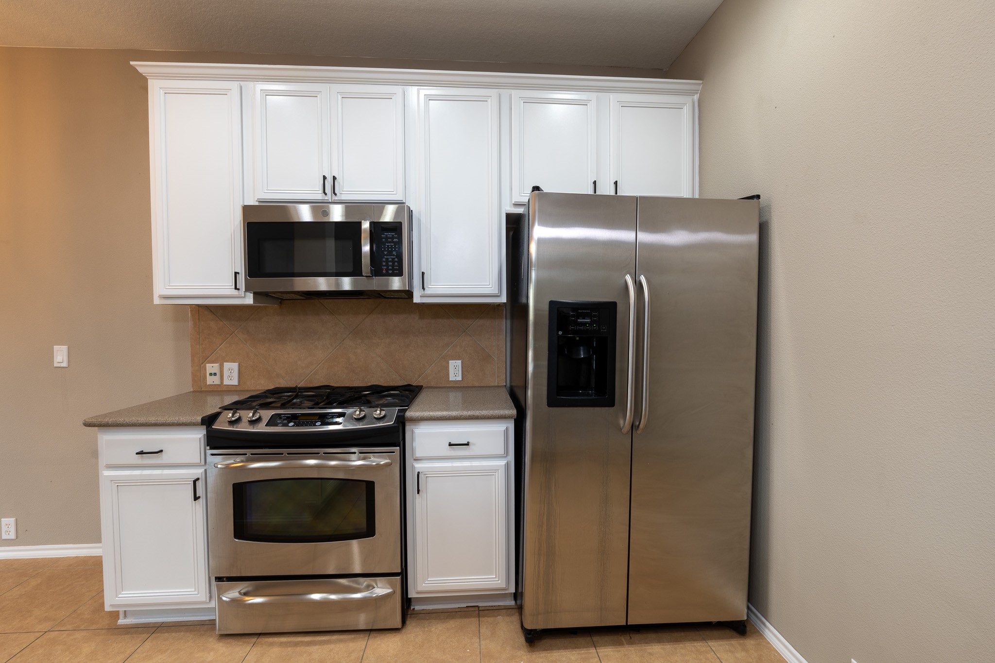 13600 Breton Ridge Street, Unit 35C Houston, TX 77070 - Photo 11 of 35 a kitchen with stainless steel appliances a stove a microwave and a hard wood floors