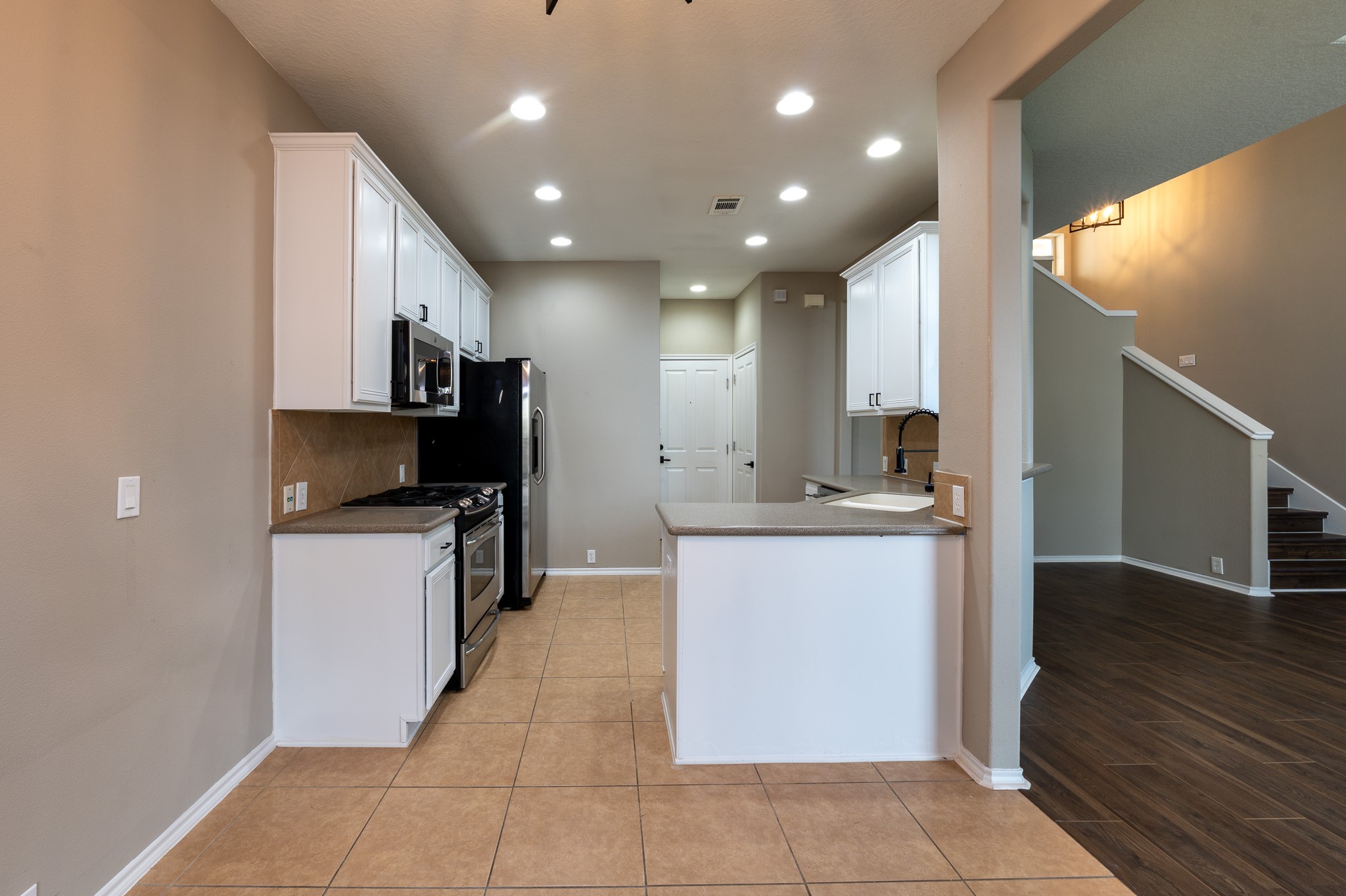 13600 Breton Ridge Street, Unit 35C Houston, TX 77070 - Photo 12 of 35 a large kitchen with kitchen island granite countertop a refrigerator a stove top oven and a sink