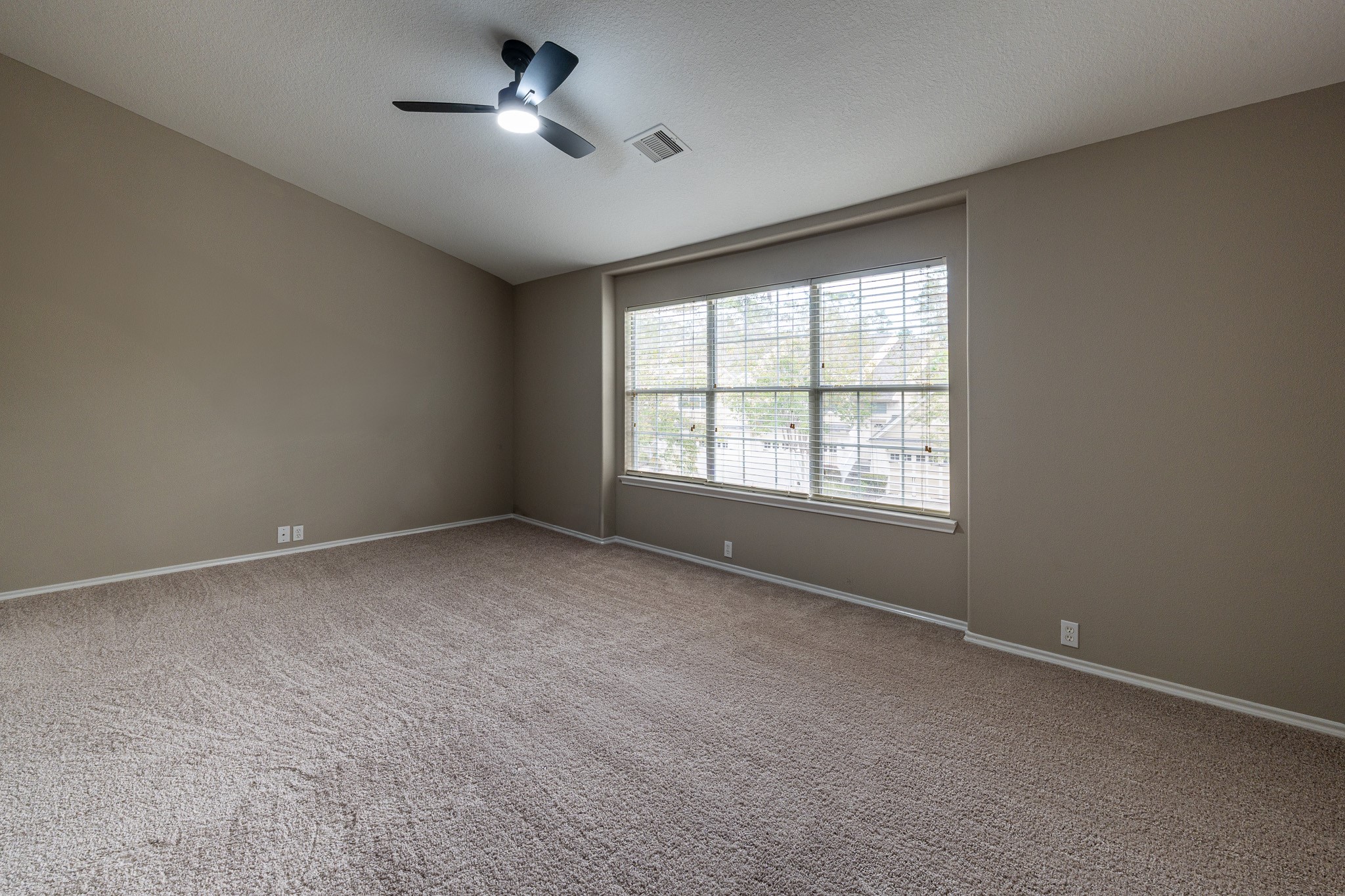 13600 Breton Ridge Street, Unit 35C Houston, TX 77070 - Photo 17 of 35 an empty room with a ceiling fan and windows