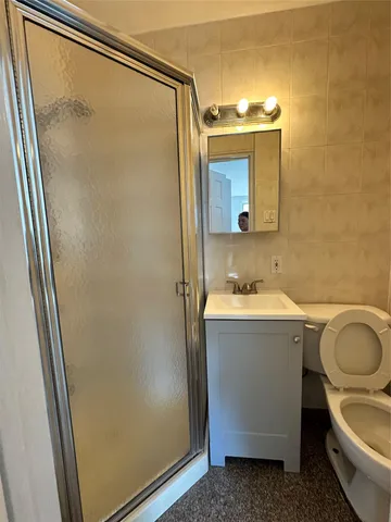 a bathroom with a granite countertop sink and mirror with shower